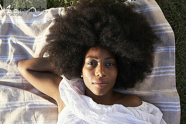 Afro-Frau entspannt sich auf einer Decke in einem öffentlichen Park